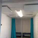 Bright room with two blue curtains, benches, and a ceiling light.